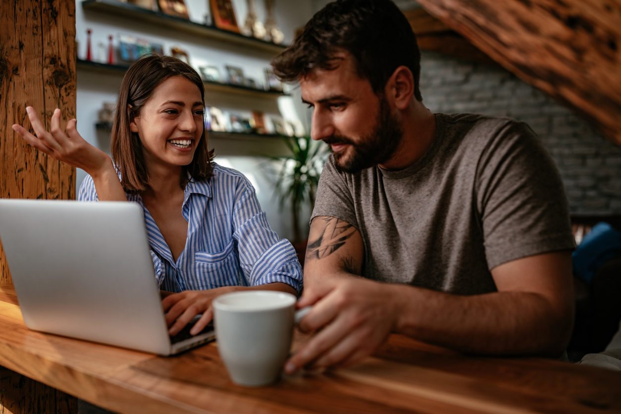 2 friends smile while looking at the laptop | AfterPullback